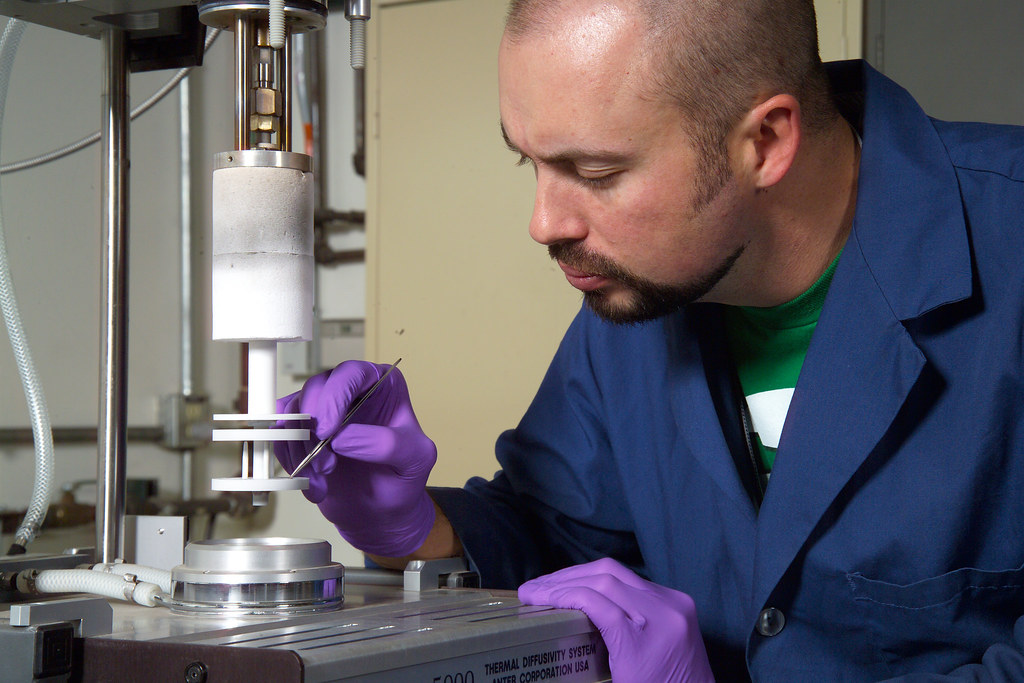 Man works on a high-temp thermocouple.  When comparing RTDs vs thermocouples, thermocouples tend to be less expensive. 
