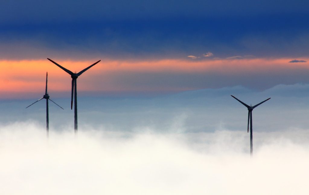 Image of three wind turbines in fog.  Wind turbine blade efficiency can be affected by surface roughness. 
